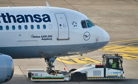 Hannover, Germany, February 8., 2020: Lufthansa aircraft is pushed over the concrete of the runway with an electrically operated trolley