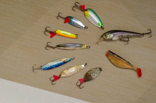 Used and new spinners, bait and silicone lures. Multi-colored fishing lures. View from above. Selective focus.