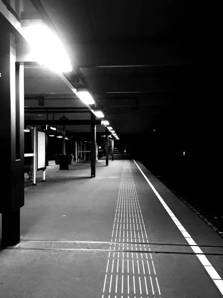 black and white image of a metrostation at night time, no people