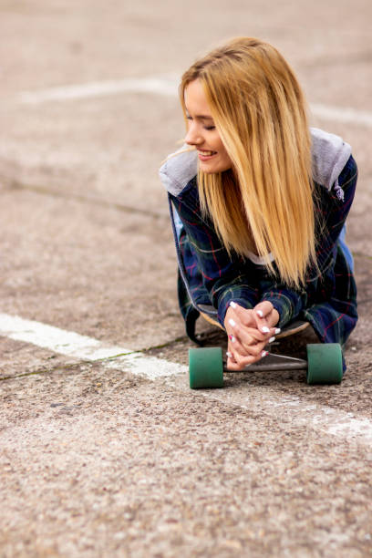 istock Beautiful young woman with skateboard 1205070837