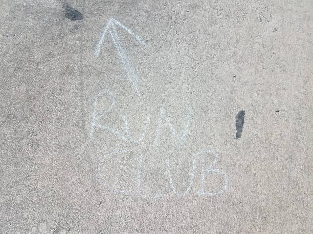 istock run club in chalk with arrow on asphalt 1205073279