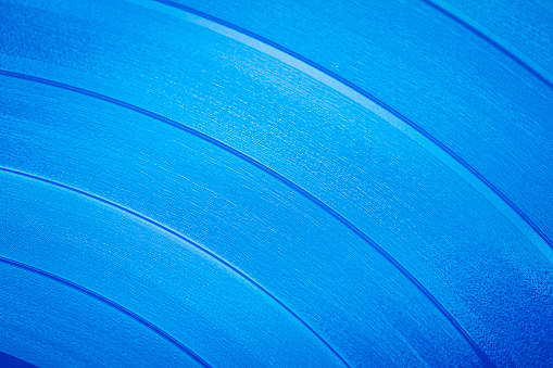 Close up of blue vinyl surface. Blue vinyl record texture background. Close up of vinyl LP record showing grooves