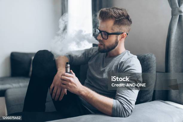 Vaping Eliquid From An Electronic Cigarette Stock Photo - Download Image Now - Electronic Cigarette, Men, Pen