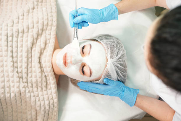 Cosmetologist doing cosmetic face mask treatment for the pretty woman. Cosmetologist doing cosmetic face mask treatment for the pretty woman. facial chemical peel stock pictures, royalty-free photos & images