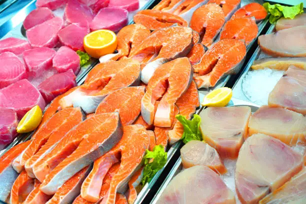 Fresh chilled fish. Salmon, tuna and catfish meat on the ice in the market.