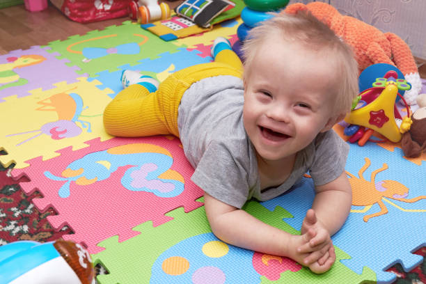 крупным планом счастливого улыбающегося мальчика, ползающего по красочному игровому коврику. ребенка на игровом коврике с игрушками. улыб� - child playground small toy стоковые фото и изображения