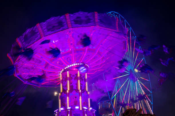istock Motion blurred carousel by night with ferris-wheel in the background 1205077446