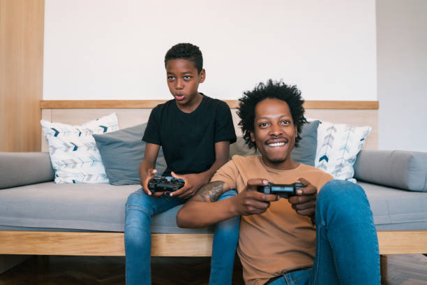 istock Father and son playing video games together at home. 1205080013