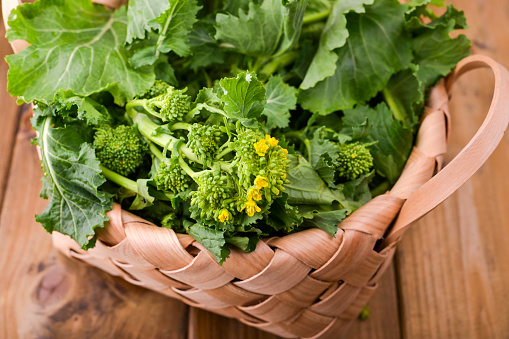 Verde nabo orgánico crudo listo para comer sobre un fondo de madera marrón. cesta con verduras frescas verdes. Comida italiana. photo