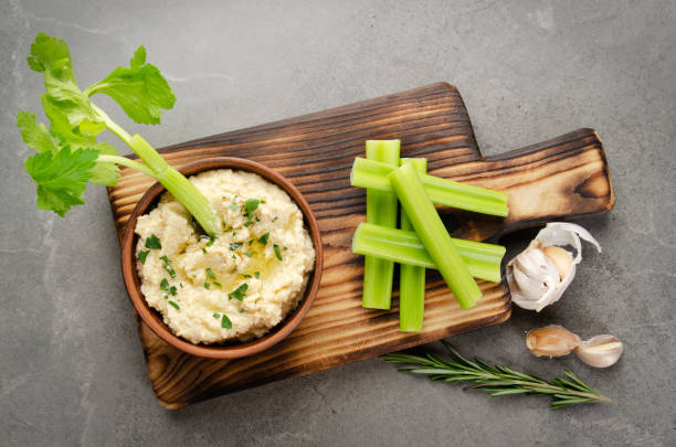 vue plate de laïc au plat de trempette de hummus de légumes garni de pois chiches et d’huile d’olive servie avec des tranches de céleri - mash bean photos et images de collection