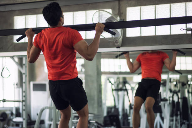 istock Fitness man pulling up bar in gym 1205087688