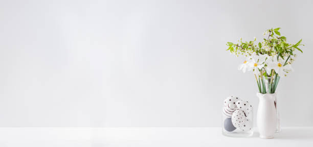 istock Home interior with easter decor. Spring flowers in a vase and easter eggs on a light background 1205087723