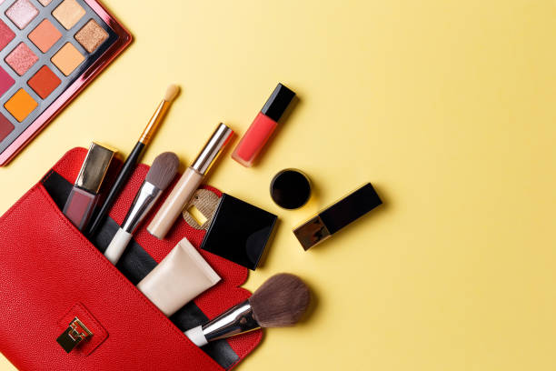 Set of professional elite decorative cosmetics for makeup on a yellow background. The concept of beauty and fashion. A red makeup bag with cosmetic beauty products: lipstick, eye shadow, foundation Set of professional elite decorative cosmetics for makeup on a yellow background. The concept of beauty and fashion. A red makeup bag with cosmetic beauty products: lipstick, eye shadow, foundation make up bag stock pictures, royalty-free photos & images