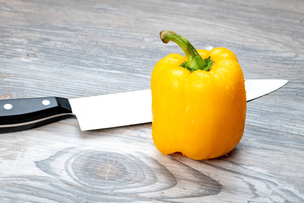 istock Sharp knife ready to cut into a yellow bell pepper 1205088967
