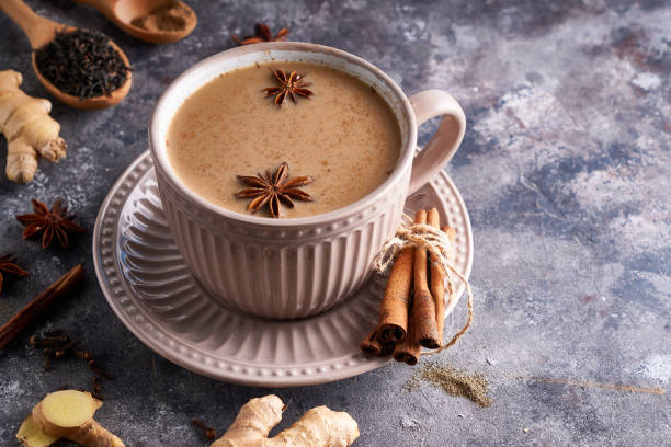istock Masala tea in cup with spices ginger, cinnamon, anise, black pepper on gray sone background 1205090365