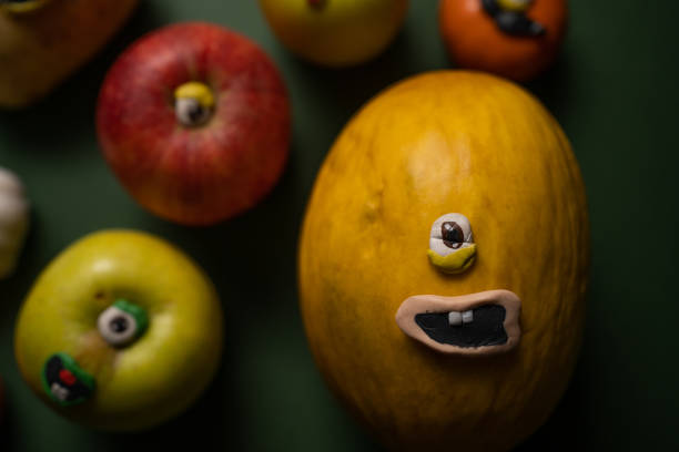 Group of fruits with eyes and mouths on a green background