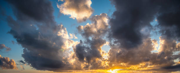 istock Dark clouds and shining sun at sunset 1205094322