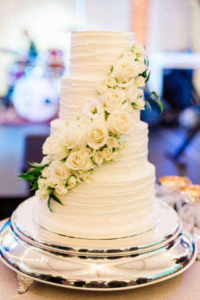 istock Three-Tiered Wedding Cake Decorated with White Roses 1205096367