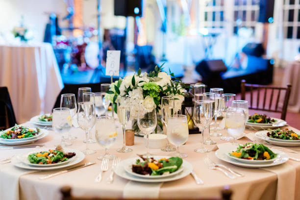 table with plated salads and napkins and wine glasses - restaurant banquet table wedding reception imagens e fotografias de stock