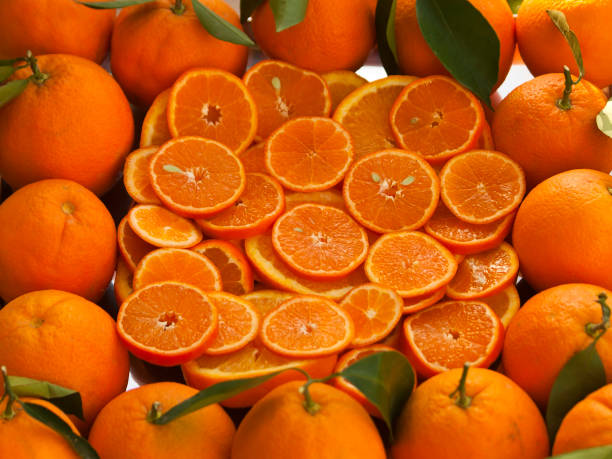 istock Round orange slices surrounded by whole oranges 1205099178
