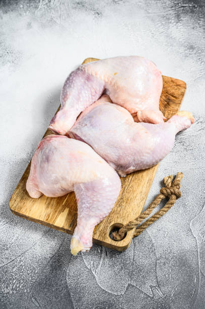 istock Raw chicken thighs on a chopping Board. Gray background. Top view 1205108274