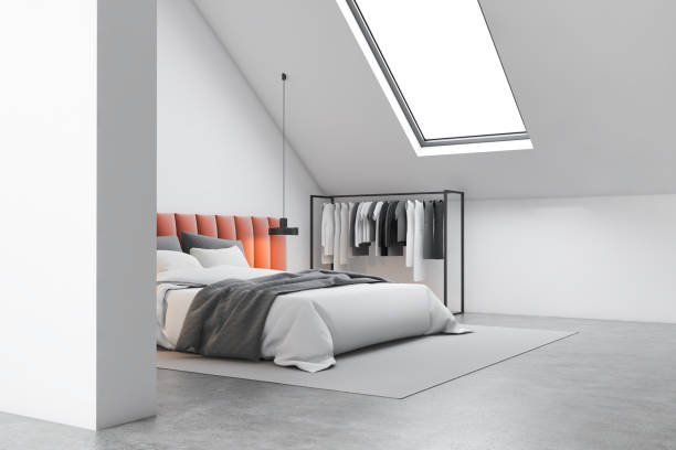 istock Attic bedroom corner with orange bed and clothes 1205111329