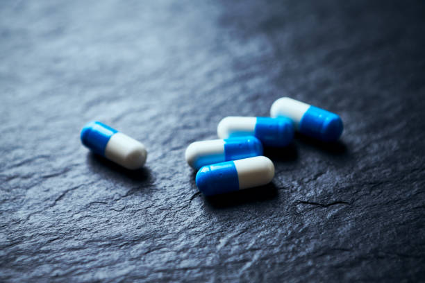 istock Sports Supplements (creatine capsules) on dark stone background. Close up. 1205111384