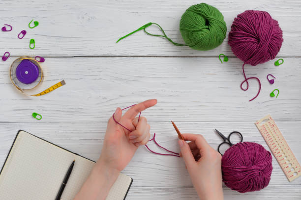 istock Background with knitting and crocheting tools and accessories, woman hands working cast on 1205112250