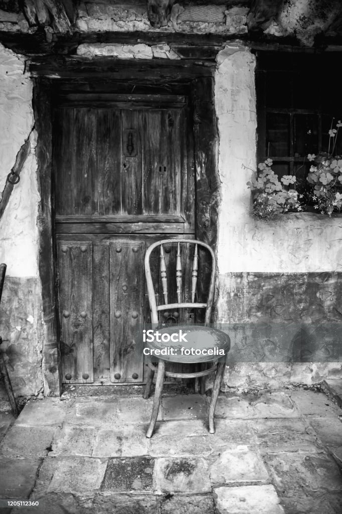 Wooden street chair Wooden chair in village street, construction and architecture, entrance Ancient Stock Photo