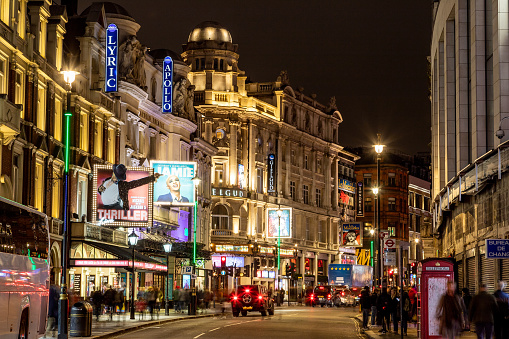 London, UK - 24th Nov 2019: Views along Shaftesbury Avenue in London's West End at night. The outside of theatres and people can be seen.