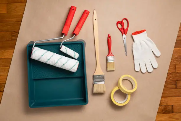 Tool kit for painting works: paint rollers and tray, brush and long-handled paint brush, masking tape, gloves, scissors