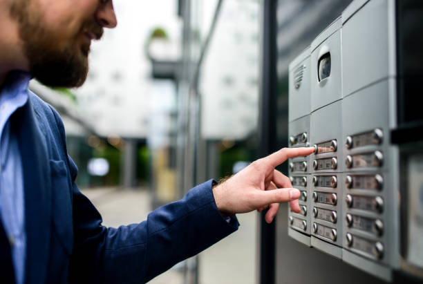 Man pushing the button and talking on the intercom stock photo