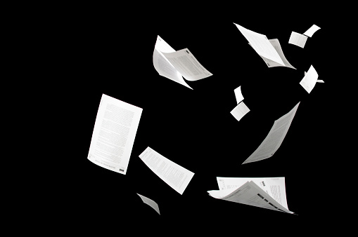 Muchos documentos de negocios voladores aislados en papeles de fondo negro volando en el aire en concepto de negocio photo