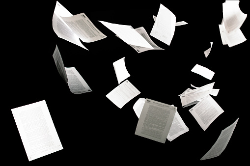 Muchos documentos de negocios voladores aislados en papeles de fondo negro volando en el aire en concepto de negocio photo