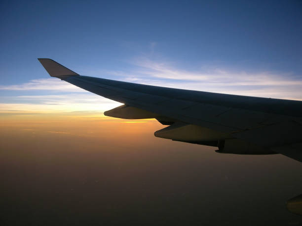 istock commercial jet wing against sunrise 1205116720