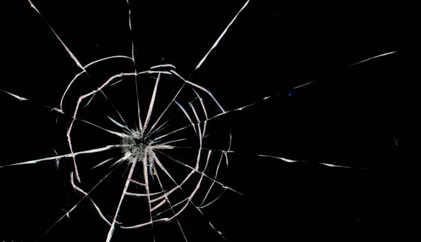istock Round white cracks in glass on black background. 1205122898
