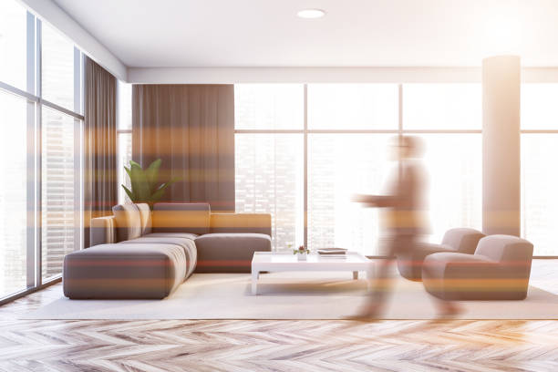 istock Man walking in gray living room with sofa 1205125179