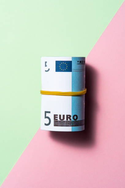 евро рулон на двухцветном цветном фоне - photography still life vertical bill стоковые фото и изображения