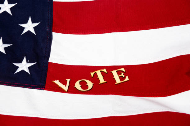istock The USA flag with letters vote staggered on a red stripe 1205127077