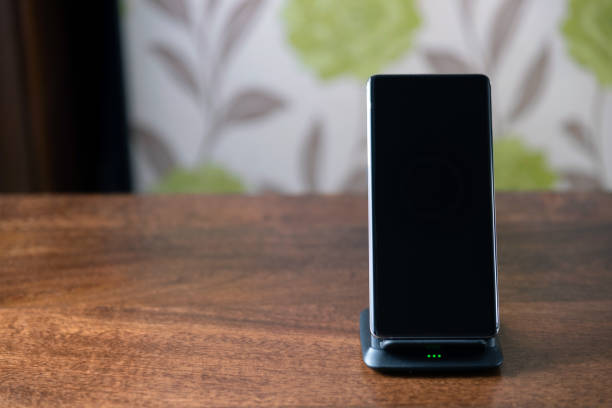 istock smartphone wireless charging on charging stand on wooden table 1205127369