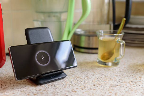 istock smartphone wireless charging on charging stand with 100 percent icon on screen on kitchen tabletop 1205127479