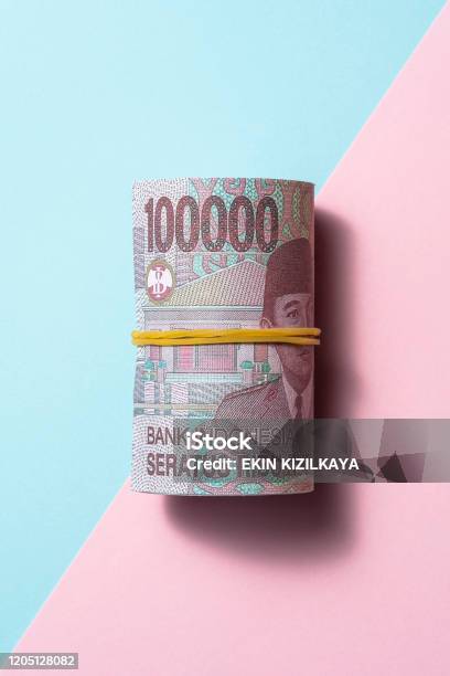 Indonesian Rupiah Roll On Two Tone Color Background Stock Photo - Download Image Now