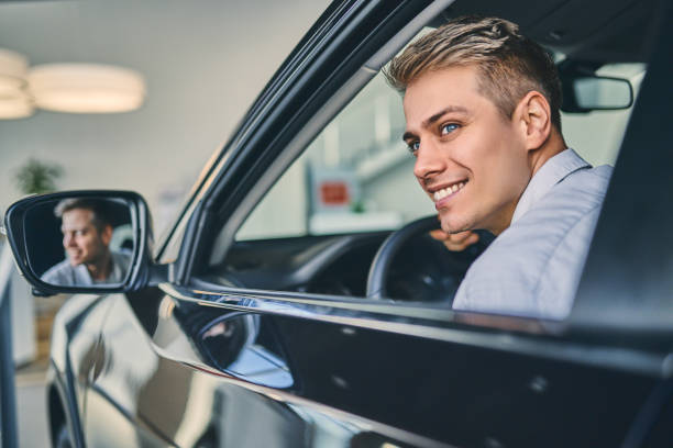 istock Stylish man sitting a new car and getting ready to drive. 1205128114