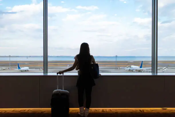 Young woman looking at view from airport terminal