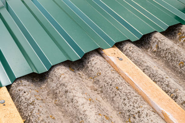 Repair of old roof. Laying a metal profiled sheet on asbestos-cement sheets. stock photo