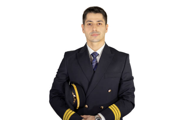 istock Male pilot with uniform + jacket, posing with confidence, holding his hat under his arm 1205132592