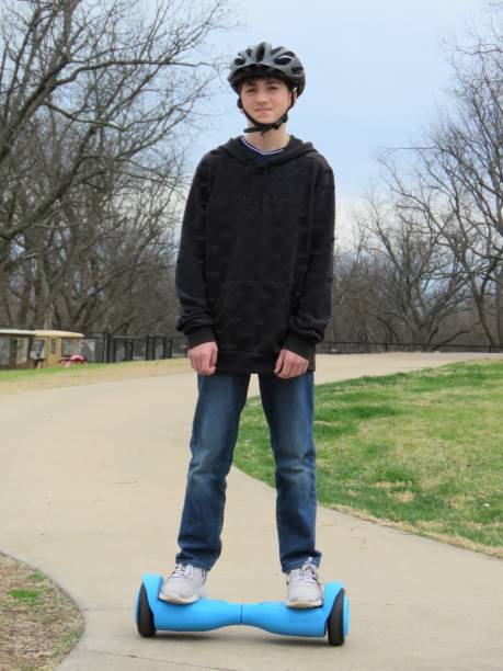 istock teenage boy riding hoverboard (gyroscooter) in park 1205134276