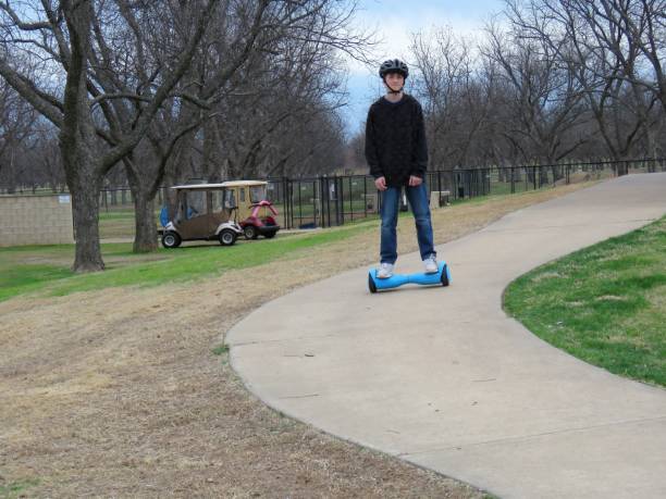 teenage boy riding hoverboard (gyroscooter) in park