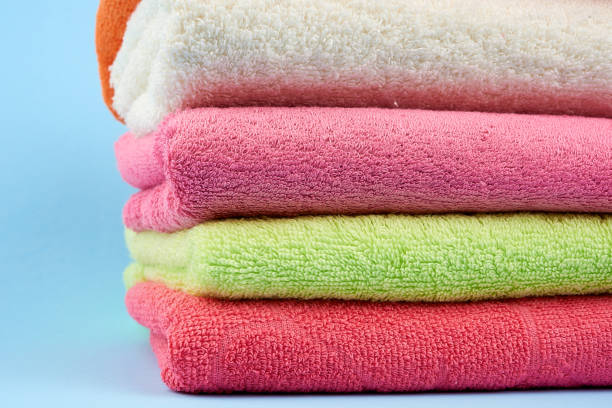istock stack of colored cotton terry towels folded against a blue background 1205135491
