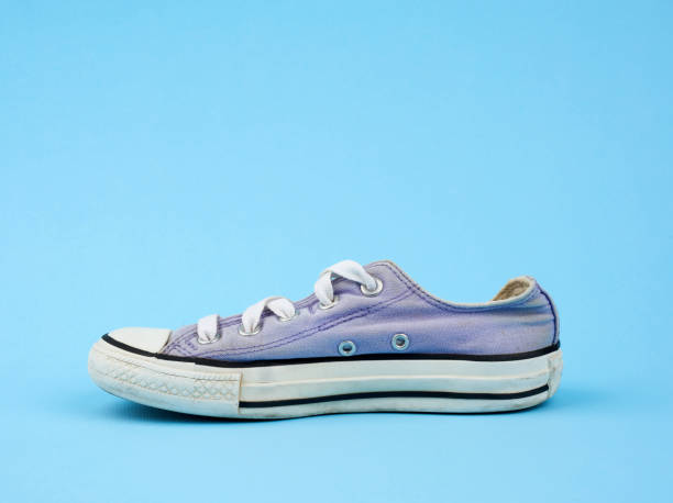 istock purple worn textile sneaker with laces on a light blue background 1205135605